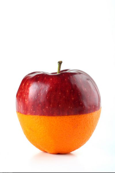 سیب و پرتقال از وسط نصف شده و روی سفید با هم قرار می گیرند