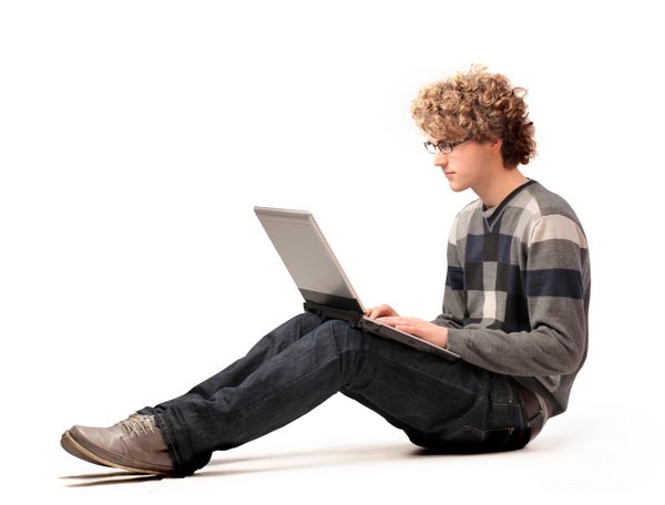 مرد جوان نشسته با استفاده از لپ تاپ