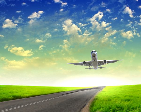 تصویر یک هواپیمای مسافربری سفید و آسمان آبی با ابرها