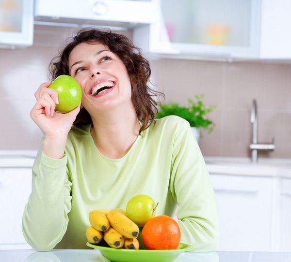 مفهوم رژیم غذایی غذای سالم رژیم غذایی زن جوان خندان میوه های تازه می خورد