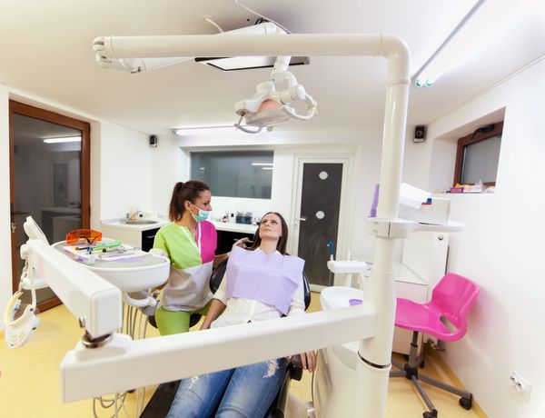 زن دندانپزشک در حال معاینه بیمارش