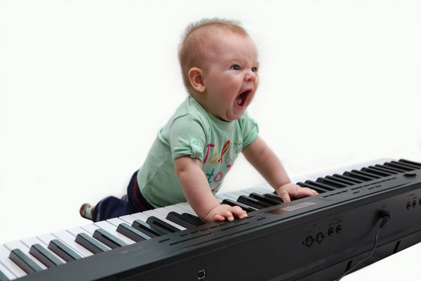 کودک نیم ساله در حال نواختن پیانو و آواز خواندن