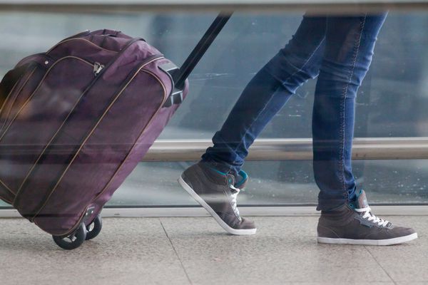 زن چمدان شما را در ترمینال فرودگاه حمل می کند