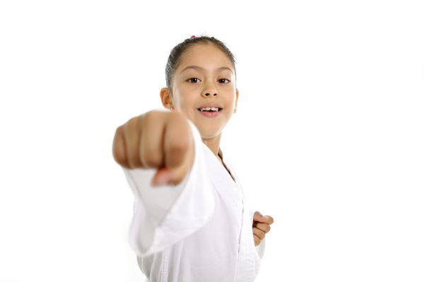 دختر بچه ناز در تمرین هنرهای رزمی کاراته حمله پانچ