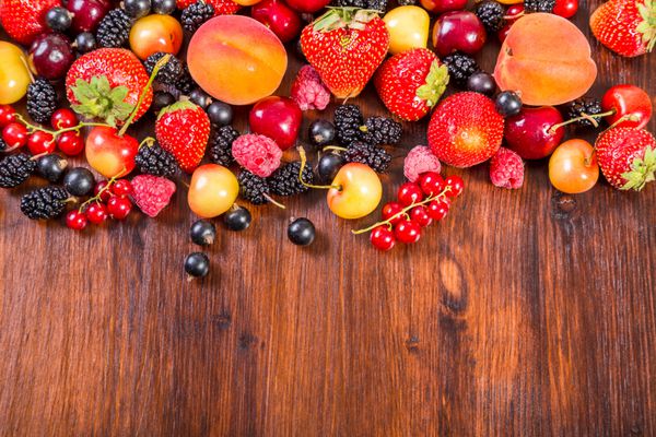 انواع توت های تازه روی میز چوبی