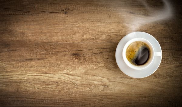 فنجان قهوه در زمینه چوبی