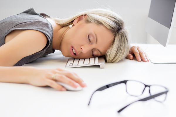زن خسته که جلوی کامپیوتر می خوابد