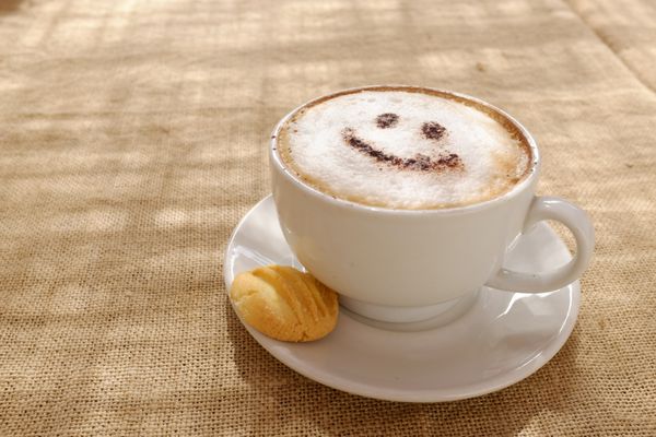کاپوچینوی قهوه با فوم یا شکلاتی با چهره شاد خندان
