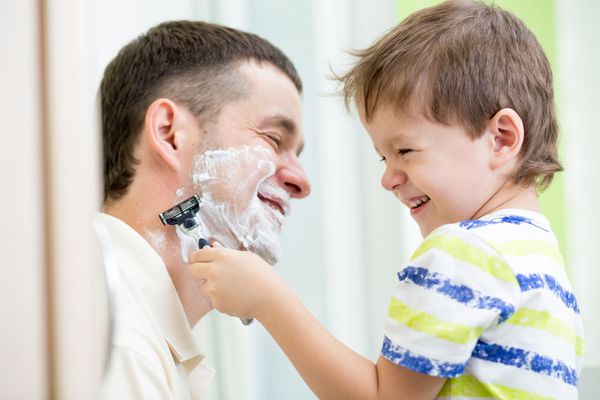 پسر بچه ای که سعی می کند ریش پدرش را بتراشد