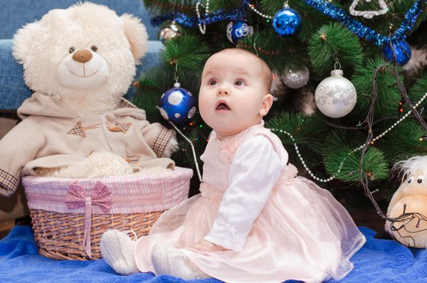 نوزاد غافلگیر شده در نزدیکی درخت کریسمس