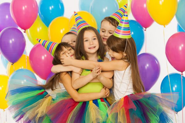 گروهی از بچه های کوچک شاد که در جشن تولد سرگرم می شوند