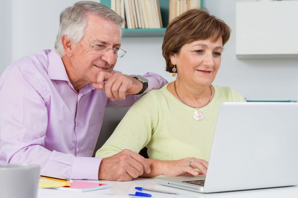 زوج سالخورده با استفاده از کامپیوتر لپ تاپ