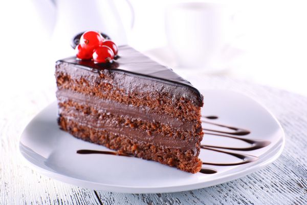 کیک شکلاتی خوشمزه روی بشقاب روی میز در زمینه روشن