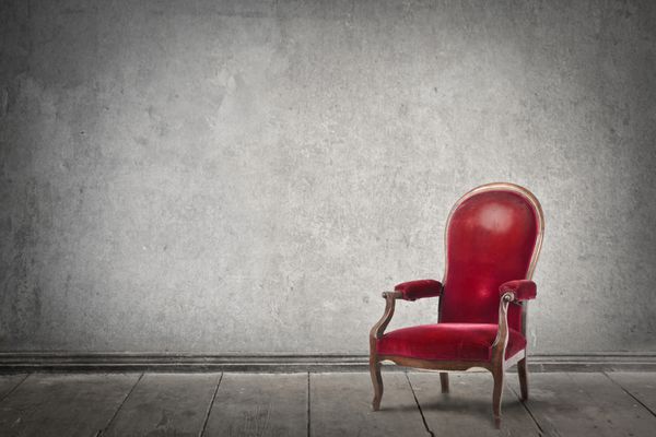 صندلی قرمز در یک اتاق خالی