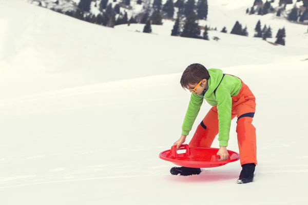 پسر جوان آماده سورتمه زدن در برف