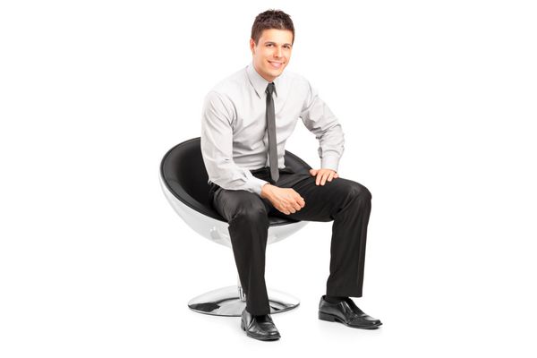 یک مرد جوان خوش تیپ که روی صندلی نشسته و در پس زمینه سفید ژست گرفته است