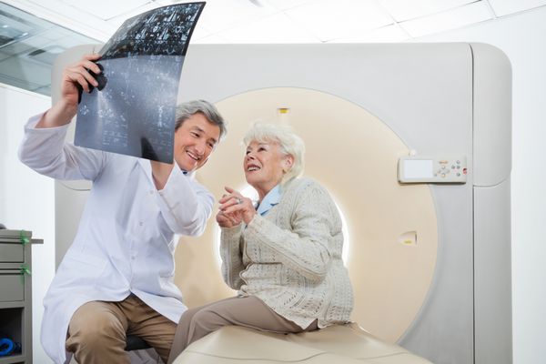 رادیولوژیست مرد بالغ با یک بیمار زن مسن که به نتایج سی تی اسکن نگاه می کند