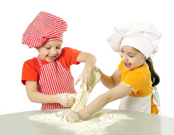 بچه ها با کلاه سرآشپز در حال آماده کردن خمیر کیک