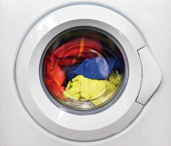ماشین لباسشویی با لباس های کثیف داخل