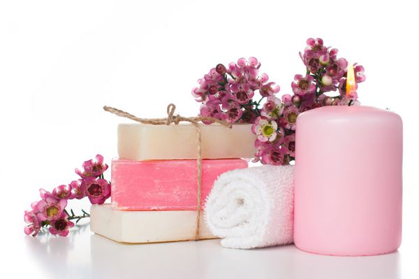 محصولات اسپا حوله شمع صابون دست ساز سفید و صورتی و شکوفه های گیلاس صورتی در پس زمینه سفید جدا شده لوازم آرایشی مراقبتی و بهداشتی