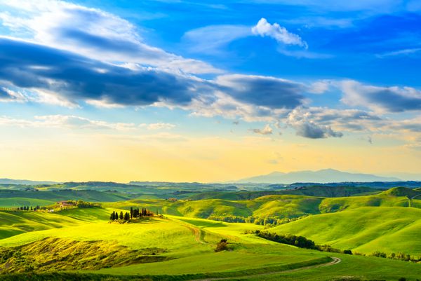توسکانی منظره غروب آفتاب روستایی مزرعه روستایی درختان سرو زمین سبز نور خورشید و ابر volterra ایتالیا اروپا