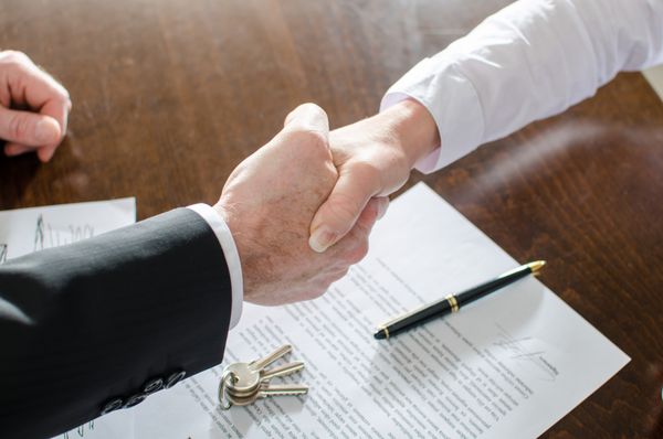 مشاور املاک پس از امضای قرارداد با مشتری خود دست می دهد