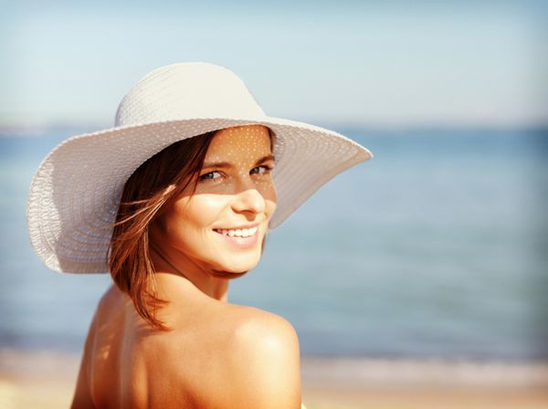 تعطیلات تابستانی و مفهوم تعطیلات - دختری با لباس بیکینی که در ساحل ایستاده است