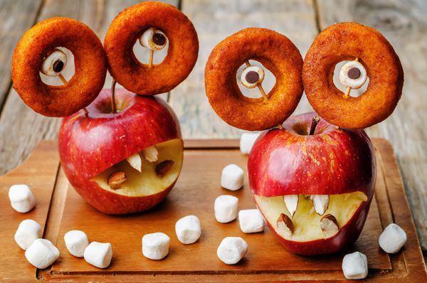 سیب مارشمالو و دونات به شکل هیولا برای هالووین برای بچه ها تونینگ تمرکز انتخابی