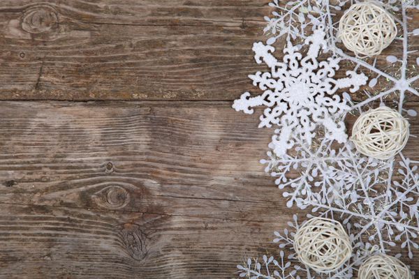 حاشیه از دانه های برف سفید در پس زمینه چوبی قدیمی تزیینات کریسمس