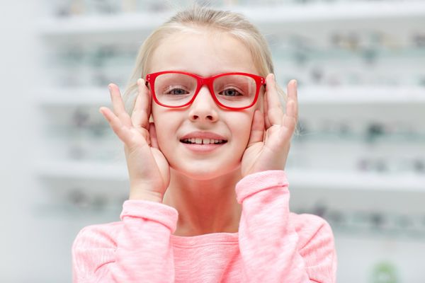 دختر کوچک با عینک در فروشگاه اپتیک