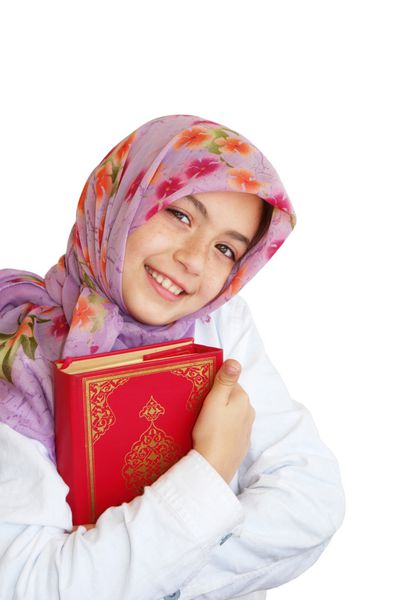 دختر کوچک مسلمان قرآن خود را در دست گرفته و لبخند می زند - منزوی