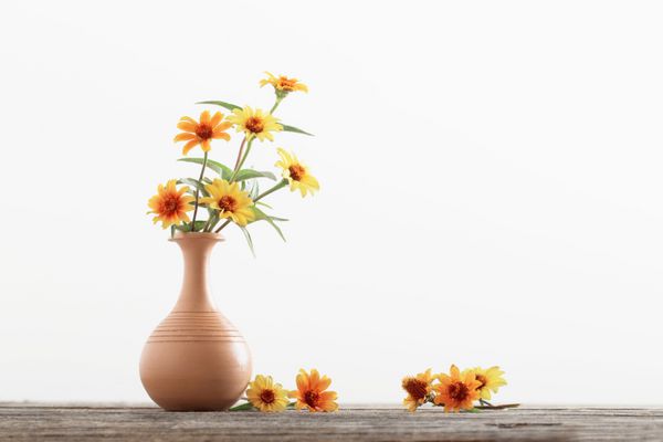گل در گلدان روی میز چوبی
