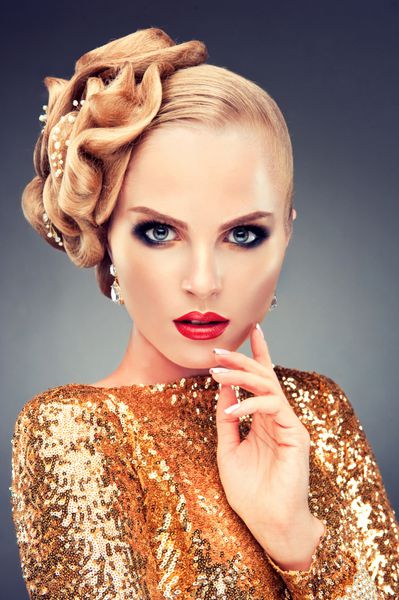 دختر مدل با لباس طلایی با مدل موی شیک پرتره یک زن جوان با مدل موی عروسی یا شب با جواهرات در موهایش زیبایی آرایشی و مد