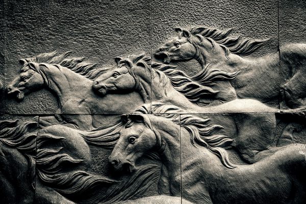 مجسمه سنگ شنی دیوار آجری پس‌زمینه دویدن اسب گله سیاه و سفید کم کلید کنتراست بالا و تن نور سخت