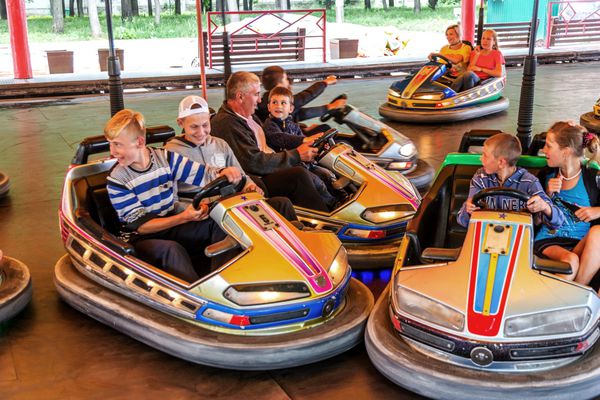 اودسا اوکراین - 13 ژوئن 2016 گروهی از کودکان پسران و دختران شاد در حال تفریح و شادی سوار بر ماشین سپر در سواری در محل نمایشگاه در یک شهربازی سرگرمی پارک موضوعی شهری