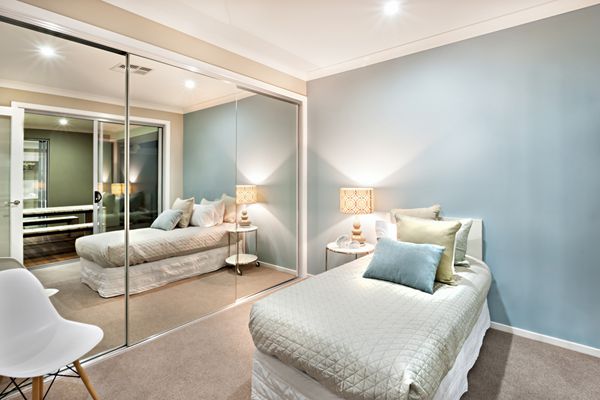 دیوارهای اتاق خواب مدرن و کلاسیک به رنگ آبی روشن است که در چراغ های رومیزی روشن می شود و یک دیوار کاملاً با آینه های بزرگ پوشانده شده است یک صندلی پشت آن و نزدیک تخت وجود دارد