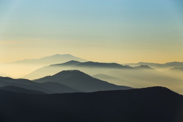 رشته کوه دوردست و لایه نازک ابر روی دره ها - کوه های مه آلود در صبح