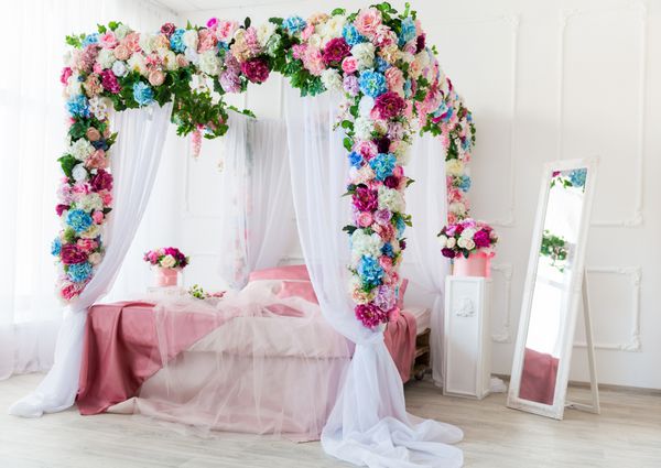تخت تزئین شده با گل در اتاق خواب روشن