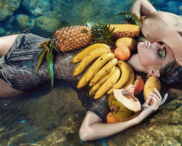 زن شیک پوش با میوه های استوایی