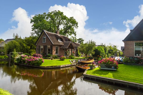 اوریسل هلند - 4 ژوئیه 2016 نمایی از قایق های بادبانی کوچک در کانال های اطراف خانه های با سقف کاهگلی Giethoorn دهکده بسیار محبوبی است