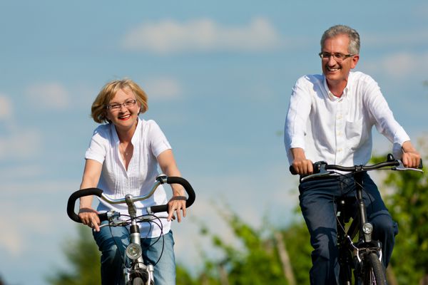 زوج بالغ شاد - افراد مسن زن و مرد که قبلاً بازنشسته شده اند - دوچرخه سواری در تابستان در طبیعت