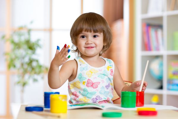 دختر بچه شاد با رنگ های رنگی نقاشی شده با دست