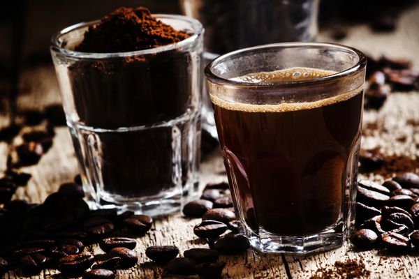 دانه های قهوه قهوه آسیاب شده اسپرسو در یک لیوان قهوه ویتاگ