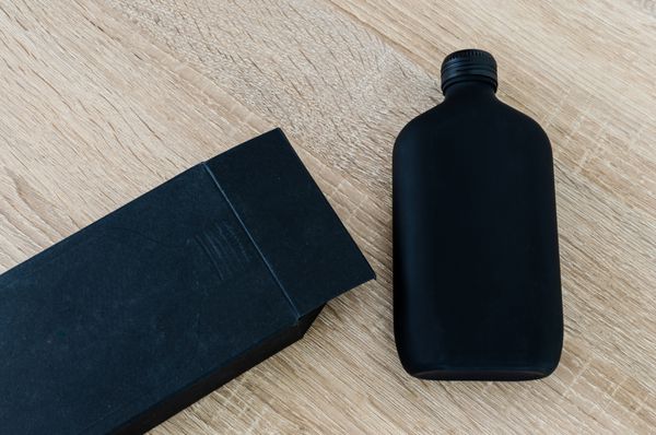 بطری سیاه و جعبه سیاه در پس زمینه چوبی