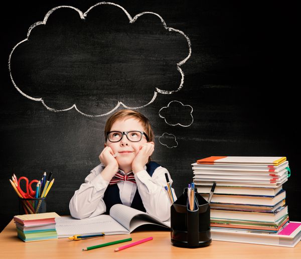 آموزش کودکان مطالعه پسر بچه در مدرسه فکر کردن یا رویاپردازی