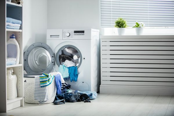 خشکشویی یک ماشین لباسشویی و انبوهی از لباس های کثیف