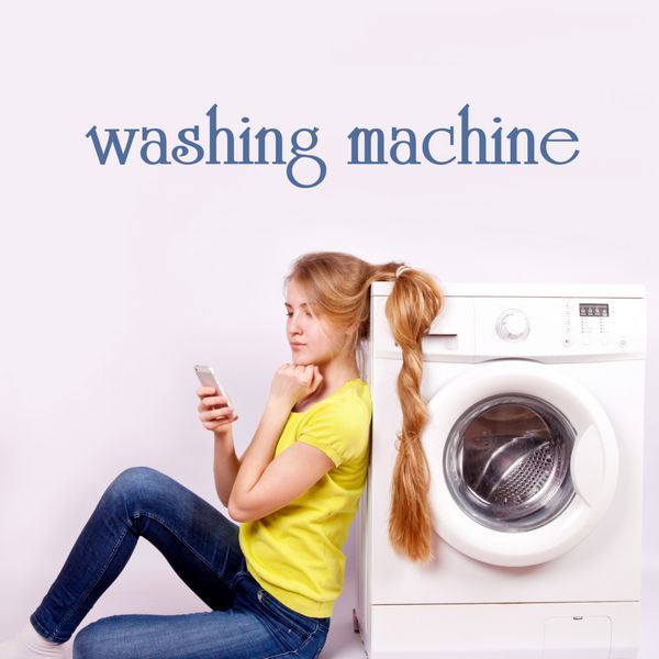 دختر زیبا با تلفن همراه و ماشین لباسشویی ایزوله