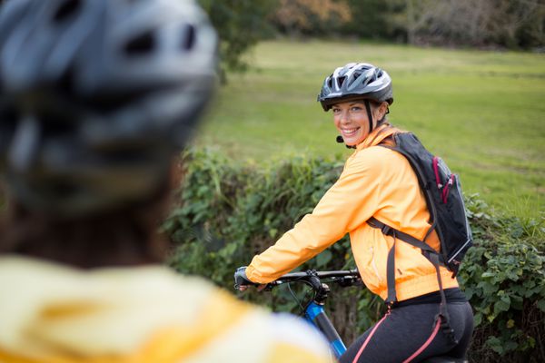 دوچرخه سوار زن در حال دوچرخه سواری لبخند می زند