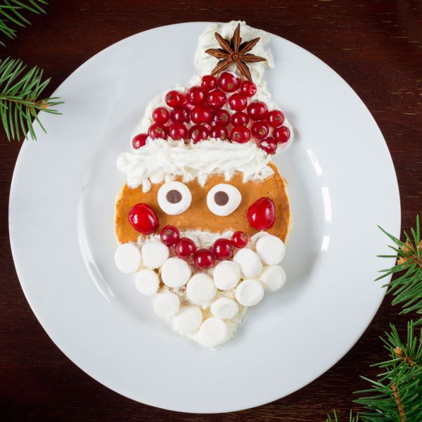 پنکیک بابا نوئل صبحانه خلاقانه هنری برای کودکان در کریسمس یا سال نو نمای بالا پس زمینه بشقاب سفید غذای کریسمس غذای سال نو غذای کودکان مربع