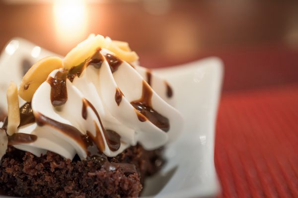 براونی شکلاتی تزیین شده با خلال بادام و یخ وانیلی